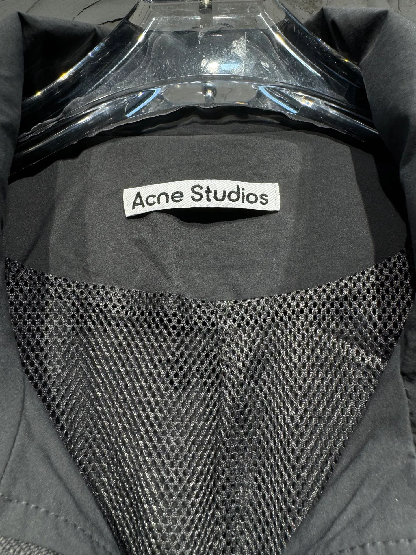 Acne Studios 26SS Large Lapel Short Jacket The fabric is made of 100% nylon (nylon/polyamide fiber) 75D high-density wrinkled nylon. The fabric has been permanently pressed and shaped by high temperature, and washed with high-pressure wrinkles at the factory to form its own irregular texture, permanently retaining the wrinkled texture, which will not disappear after washing. Matte matte coating removes the plastic glossy surface of nylon itself to create a low-key matte paper feel. Three-proof micro-coating, weak waterproof, anti-fouling, anti-static treatment, not easy to get dust. The interior is made of full-width mesh Breathable nylon lining, which reduces the stickiness of the nylon fabric to the body, improves air circulation, prevents sweating from sticking to the skin, and the zipper does not rub against the skin. The version adopts the raglan split topstitching process, and the front and rear panels are divided diagonally to expose even stitching. The three-dimensional dropped shoulders are loose and the fit is increased to increase the margin of movement. The back neckline is three-dimensional and high-density computer embroidered, and the embroidery lines are dense and not prickly. Customized all-metal matte nylon zipper, Genuine Leather embossed brand letters on the zipper leather tab, zipper tape with same color nylon fit to the body, double-locked reinforcement on both sides of the zipper to prevent pulling and tearing. Color: Gray Size: S M L